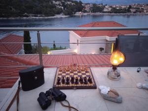 a table with a chess board and a lamp on a balcony at Apartment Puntinak in Selca