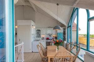 eine Küche und ein Esszimmer mit Tisch und Stühlen in der Unterkunft Grimaud 185 - Kustpark Village Scaldia in Hoofdplaat