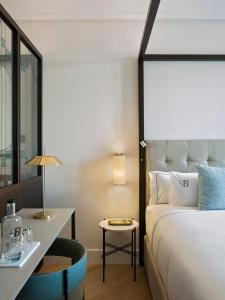 a bedroom with a bed and a table and a chair at Antiga Casa Buenavista in Barcelona