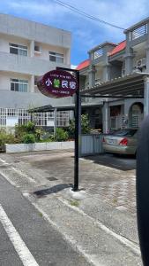 ein Schild auf einem Parkplatz vor einem Gebäude in der Unterkunft Taitung Frog Homestay in Taitung