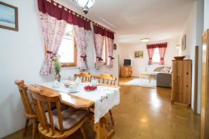 a kitchen and living room with a table and chairs at Apartmaji Katrnjek in Bohinj