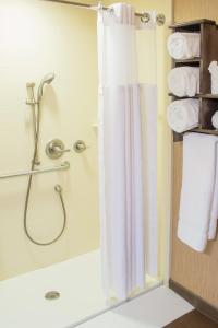 a bathroom with a shower and a towel rack at Little Missouri Inn & Suites Watford City in Watford City