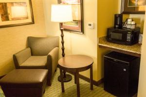 a room with a chair and a table and a lamp at Little Missouri Inn & Suites Watford City in Watford City