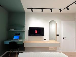 sypialnia z biurkiem z laptopem i telewizorem w obiekcie Dolce far niente Apartment w Tiranie