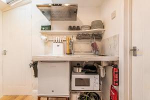 a small kitchen with a sink and a stove at The Artists Workshop - Norfolk Holiday Properties in Norwich