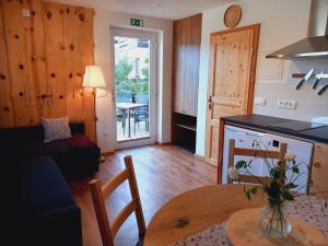 ein Wohnzimmer mit einem Tisch und einer Küche in der Unterkunft Marovt App in Bled