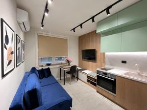 salon z niebieską kanapą i kuchnią w obiekcie Dolce far niente Apartment w Tiranie