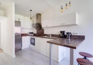 a kitchen with white cabinets and a wooden counter top at L'HYPERCENTRE de Suresnes in Suresnes