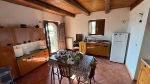 a kitchen with a table with chairs and a refrigerator at Antico Casale da Gemma - Fuscaldoapartment in Fuscaldo +37 photos