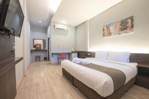 a hotel room with a large bed and a flat screen tv at Tarnsiri Boutique Resort in Kanchanaburi City