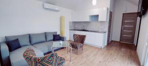 a living room with a couch and a table and a kitchen at Uroczysko Warta in Uniejow