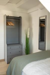 a bedroom with a bed and a dresser and a mirror at Schöne Stadtwohnung in Friedrichshafen am Bodensee in Friedrichshafen