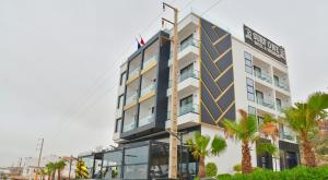 a hotel building with palm trees in front of it at Surf One Hotel in Agadir