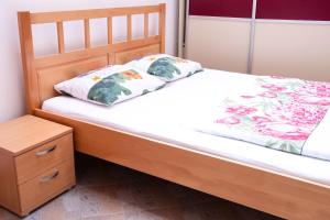 - un lit avec un cadre de lit en bois et une table de nuit dans l'établissement Apartment Ovcica with terrace in Izola, à Izola