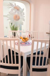 une table blanche avec deux chaises et un vase avec une fleur dans l'établissement Apartment Ovcica with terrace in Izola, à Izola