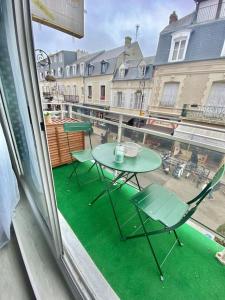 a patio with a table and chairs on a balcony at Superbe Studio Balcon Emplacement nº1: Place Morny in Deauville