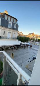 a view of a building and a patio with tables at Superbe Studio Balcon Emplacement nº1: Place Morny in Deauville