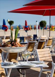a table with a bowl of food and wine glasses on the beach at Superbe Studio Balcon Emplacement nº1: Place Morny in Deauville