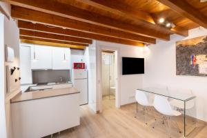 cocina con armarios blancos y mesa de cristal en THE SAILOR HOUSE, Duplex Palma Center, en Palma de Mallorca