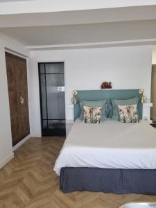 1 dormitorio con 1 cama grande y cabecero azul en Joséphine, en Bastia