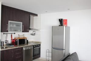 a kitchen with a stainless steel refrigerator and cabinets at Casas do Aidro in Freches