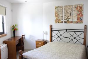 um quarto com uma cama e uma pintura na parede em Casas do Aidro em Freches