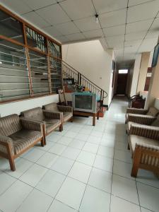 ein Wartezimmer mit Sofas und einem TV in einem Gebäude in der Unterkunft Airtown Guest House in Jetis