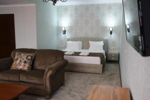 Habitación de hotel con cama y sofá en MirOtel Hotel, en Astana