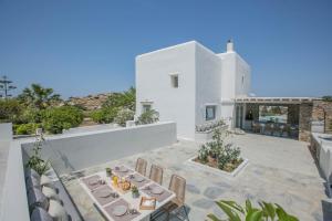 a white villa with a table and chairs on a patio at Villa Ada Mykonos in Mýkonos City
