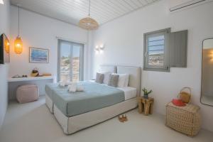 a white bedroom with a bed and a window at Villa Ada Mykonos in Mýkonos City +53 photos