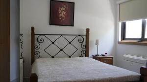 um quarto com uma cama e um quadro na parede em Casas do Aidro em Freches mais 37 fotografias
