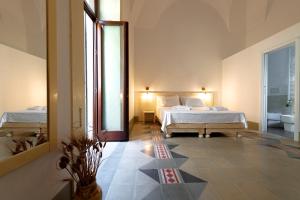 a bedroom with two beds and a large mirror at Damasa Rooms in Lecce