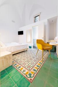 a bedroom with a bed and a chair and a rug at Damasa Rooms in Lecce