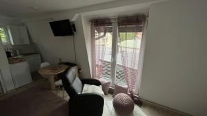 - un salon avec une chaise, une table et une fenêtre dans l'établissement City apartment 3, à Visoko