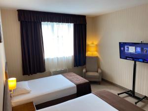 a hotel room with two beds and a flat screen tv at Hotel 7ya in Krasnosilske
