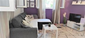 Una sala de estar con un sofá y un televisor. en Martina, en Supetar