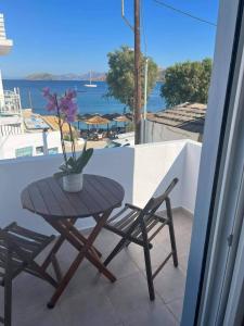 una mesa y sillas en un balcón con vistas al océano en White island rooms en Panteli