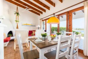 a dining room and living room with a table and chairs at Bellamirada - Punta Prima Playa in Punta Prima