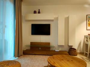 un soggiorno con TV e tavolo di Flor De Cactus a Costa Teguise
