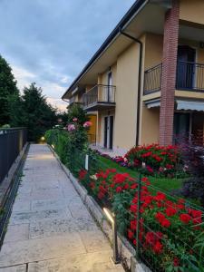 a walkway next to a building with red flowers at Casa Andrè in Pescantina