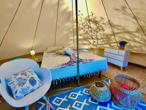 - une chambre avec un lit et des chaises dans une tente dans l'établissement La Tenda a Marina Serra di Casa Camilla Journey, à Marina Serra