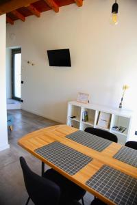 a room with a table with a tv on a wall at Our Happy Place - casa vacanze per il viaggiatore Slow in Mandello del Lario