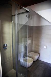 a bathroom with a toilet and a glass shower at Our Happy Place - casa vacanze per il viaggiatore Slow in Mandello del Lario