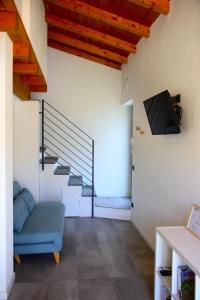 a living room with a blue couch and a staircase at Our Happy Place - casa vacanze per il viaggiatore Slow in Mandello del Lario