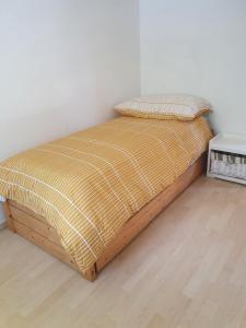 uma cama com uma estrutura de madeira num quarto em Appartement Fully em Fully