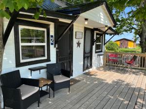 un porche de una casa pequeña con sillas y mesa en The Coastal Cabins in New Brunswick, en Cape Tormentine