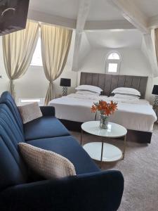a bedroom with two beds and a couch and a table at Villa al Tempio in Pazardzhik