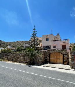 a house with a stone wall and a garage at Tranquil Apartments in Naxos Chora