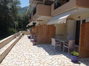 a patio with a table and chairs next to a building at Vessarios in Nikiana +24 photos