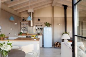 a kitchen with a refrigerator and a table at La Guarida Lugás cabañas de lujo in Villaviciosa